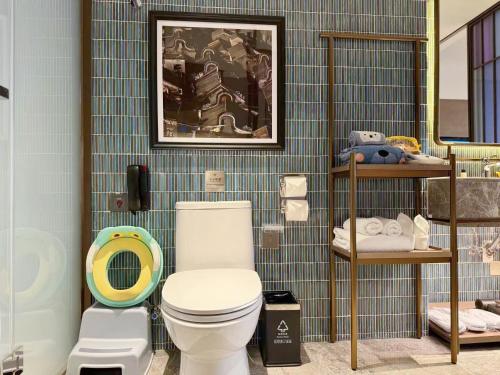 a bathroom with a toilet and a blue tiled wall at Baiyun Hotel Guangzhou in Guangzhou