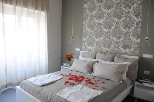 ein Schlafzimmer mit einem Bett mit roten Blumen darauf in der Unterkunft Alma Mater B&B in Rom