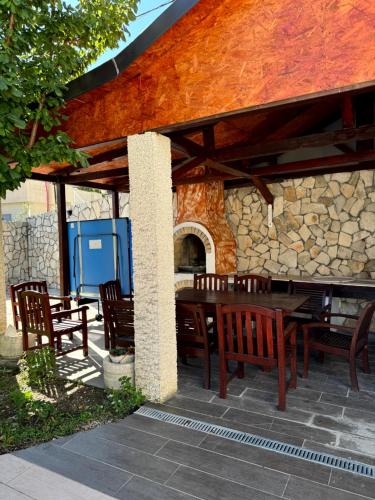 a wooden table and chairs under a stone building at Sunset Pool Retreat in Zagrađe