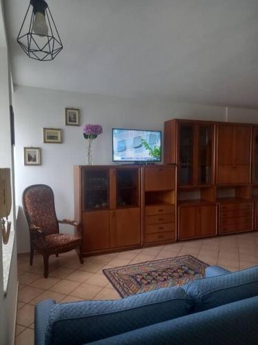 a living room with a couch and a tv and a chair at Da Elena e Michele in Coazze