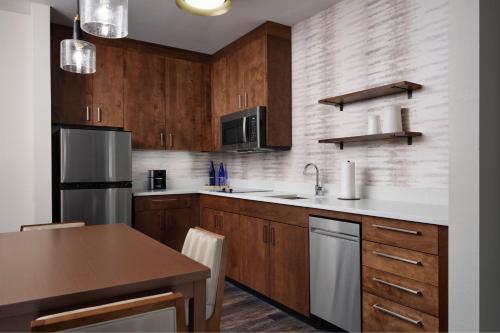 a kitchen with wooden cabinets and a wooden table at Inn at Bellefield Residence Inn by Marriott in Hyde Park