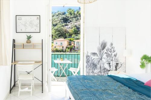 une chambre avec un lit et un balcon avec une table dans l'établissement Le belle brise cosy studio, à Menton