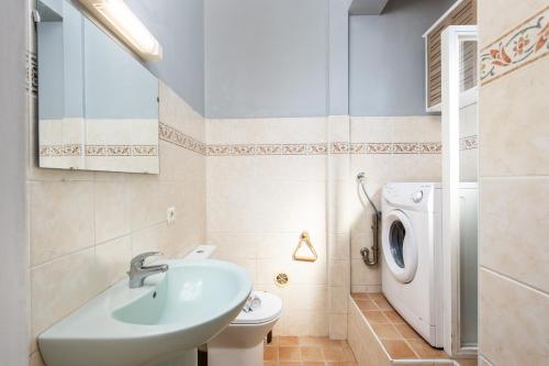 une salle de bain avec un lavabo et une machine à laver dans l'établissement Le belle brise cosy studio, à Menton