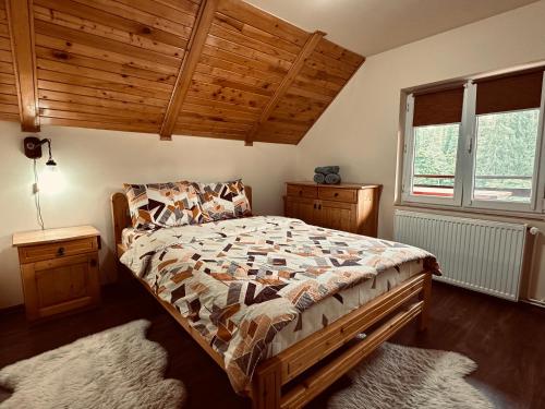 a bedroom with a bed and a wooden ceiling at Cabana Scruba in Topliţa