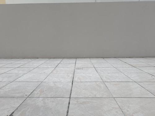 an empty room with a tile floor and a white wall at Conforto e ótima localização! in Santa Maria