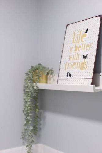 a shelf with a plant and a sign on it at Oporto Seside Village - Casa Flores in Matosinhos