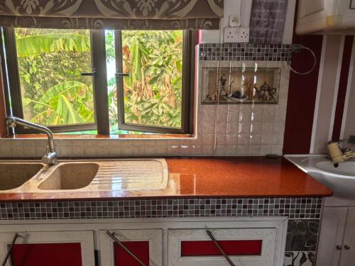 a kitchen with a sink and a window at Soothing home in Brisée Verdière