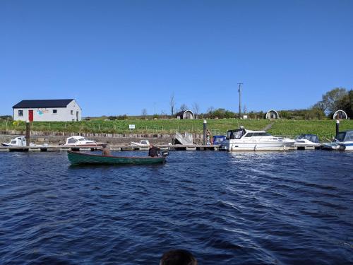 a man in a boat in the water with other boats at Rose Glamping pod in Derrylin