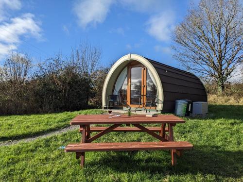 a picnic table and a dome tent in a field at Rose Glamping pod in Derrylin