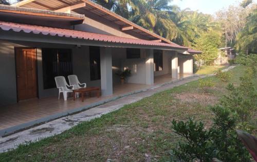 a house with two chairs and a table on a porch at BaanPhong Lanta in Ko Lanta