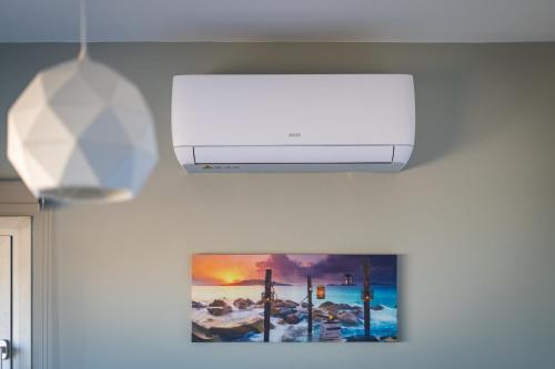 a white air conditioner is hanging on a wall at Majestic Sunset Salt Lake Views 300m From Beach in Larnaka