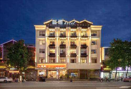 Hanqiyuにある督增酒店の夜の街路にある大きな白い建物