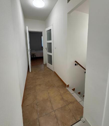 a hallway with white walls and a tile floor at CasaTiffany - Intera casa in Piacenza