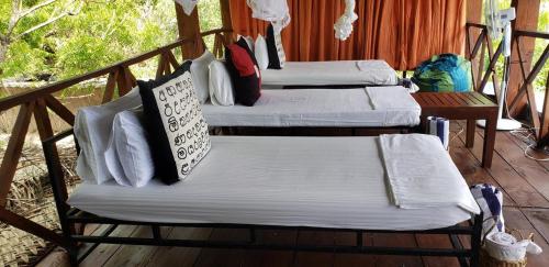 a group of four beds sitting on a porch at Nagenahira Beach Villa in Nilaveli