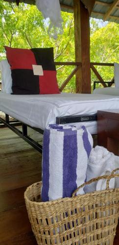 a basket with pillows and towels on a bed at Nagenahira Beach Villa in Nilaveli