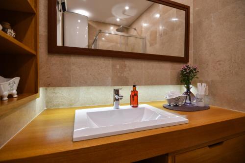 a bathroom with a white sink and a mirror at Apart hotel M S KATUNJANIN in Herceg-Novi