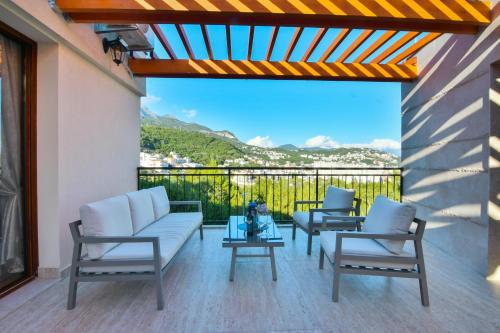 a patio with chairs and a table with a view at Apart hotel M S KATUNJANIN in Herceg-Novi