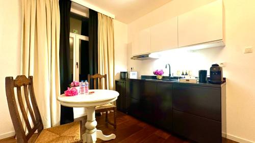 a small kitchen with a white table in a room at Royal Horses in Overijse