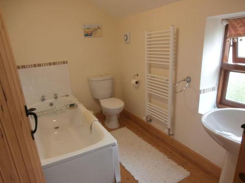 une salle de bain avec une baignoire, des toilettes et un lavabo dans l'établissement Clares Cosy Cottage, à Louth
