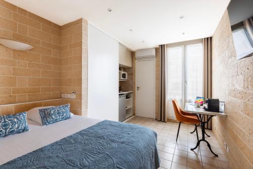 a bedroom with a bed and a desk with a computer at Appart Hôtel Résidence Courcelle in Levallois-Perret