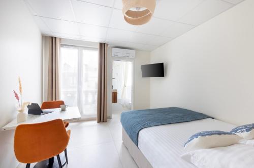 a bedroom with a bed and a desk and a tv at Appart Hôtel Résidence Courcelle in Levallois-Perret