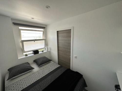 - une chambre avec un lit doté d'oreillers noirs et une fenêtre dans l'établissement Appartement cosy à 2 pas de la Croisette, à Cannes