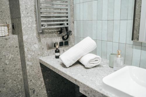 a bathroom with a sink and towels on a counter at Arkada Wadowice in Wadowice