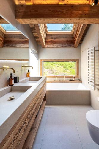 une salle de bain avec deux lavabos et une baignoire dans l'établissement Chalet TheMoon - La Clusaz, à La Clusaz