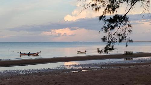 two boats in the water on a beach at Baan rabianglay 2 in Ban Hin Sam Kon