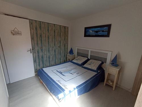 une chambre avec un lit avec une couette bleue dans l'établissement LeWindy Barcares Terrasse Confort Calme Fibre Vélos Bord Lac Proximité Plage Lydia Coudalere, au Barcarès