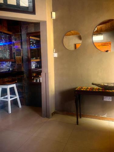 a bar with a table and two mirrors on the wall at Mukani Guesthouse in Lobatse
