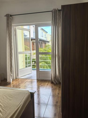 a bedroom with a bed and a large sliding glass door at Jems Appartment Villa in Mare Sèche