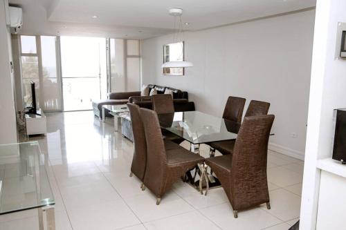 a dining room with a glass table and chairs at Seaside retreat for urban explorers above Mall in Maputo