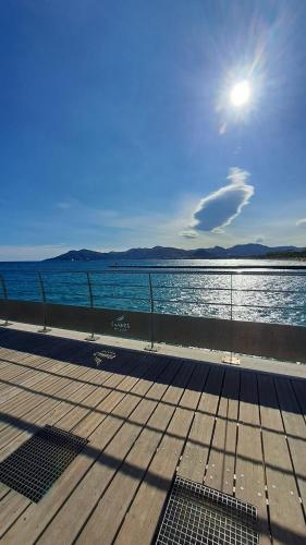 une promenade à côté d'une masse d'eau dans l'établissement Ocean View Royal Palm, à Cannes