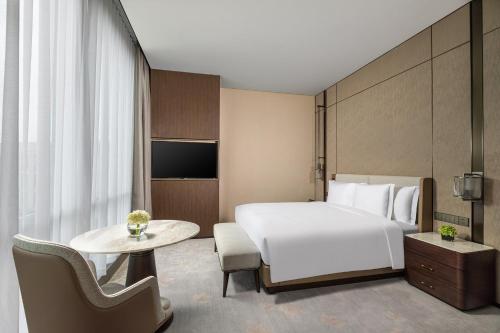 a hotel room with a bed and a table at Crowne Plaza Shanghai Hongqiao by IHG in Shanghai
