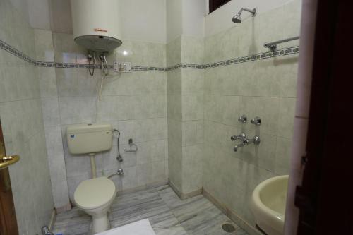 a bathroom with a toilet and a sink at Hotel New Mamta in Srinagar