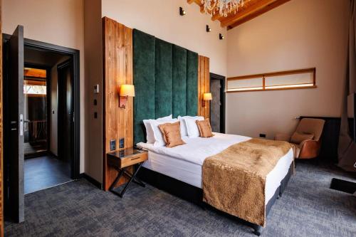 Un dormitorio con una cama grande con cabecero verde. en Prestigious Luxury Villa with private pool in the heart of Pirin, en Banya