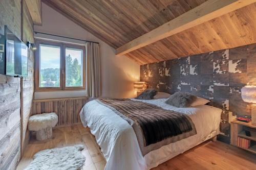 une chambre avec un grand lit et une fenêtre dans l'établissement Très bel appartement Duplex 9 couchages, à Megève
