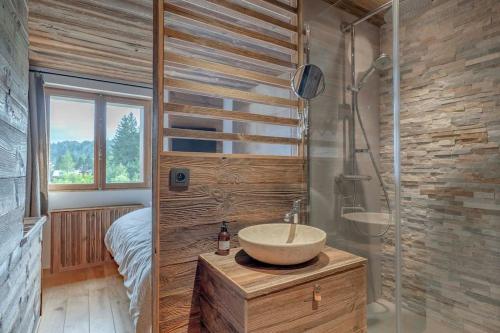 une salle de bain avec un lavabo et une douche et un lit dans l'établissement Très bel appartement Duplex 9 couchages, à Megève