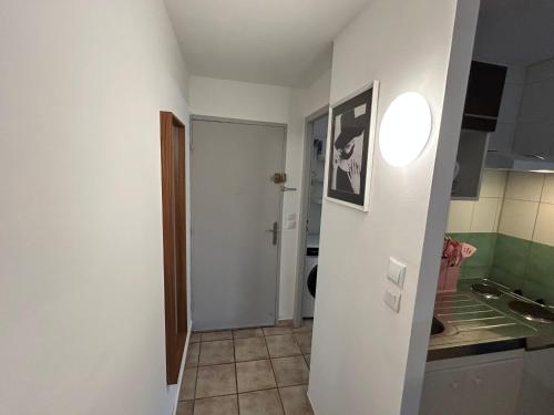 Elle comprend une petite cuisine avec un évier et un mur blanc. dans l'établissement Studio Nîmois bien équipé avec parking, à Nîmes