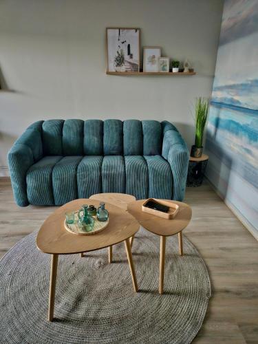 un salon avec un canapé bleu et une table basse dans l'établissement Le cocon du voyageur, à Bruay-la-Buissière