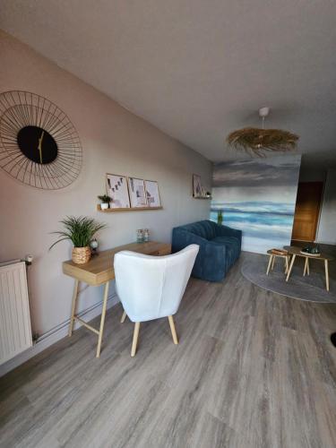 un salon avec un canapé bleu et une table dans l'établissement Le cocon du voyageur, à Bruay-la-Buissière