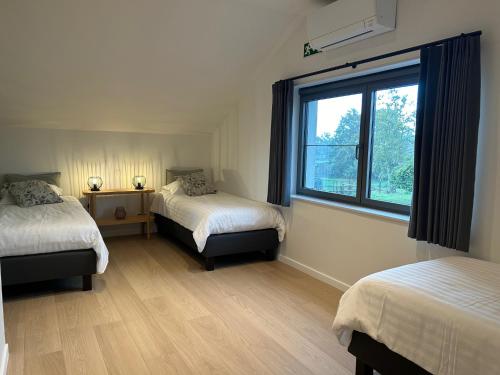 a room with two beds and a window at Vakantiewoning Laurijn in Bilzen