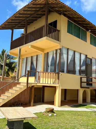 a large house with a balcony and a table at Casa Águas de Olivença - Pé na Areia in Olivença