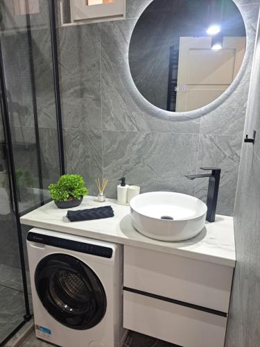 a bathroom with a washing machine and a sink at Belvárosi Lux Apartman 2 in Vásárosnamény