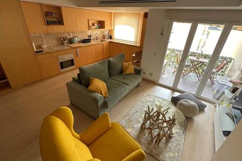 a living room with a couch and a kitchen at Beachfront apartment with a pool- Parede in Parede