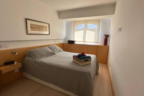 a bedroom with a bed with a basket on it at Beachfront apartment with a pool- Parede in Parede