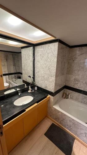 a bathroom with a sink and a bath tub at Beachfront apartment with a pool- Parede in Parede