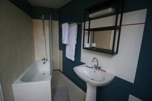 une salle de bain avec un lavabo et une baignoire dans l'établissement T2 centre ville de Dreux - Entrée autonome, à Dreux