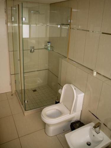 a bathroom with a shower and a toilet and a sink at Beachfront Luxury Exquisite Retreat above Mall in Maputo